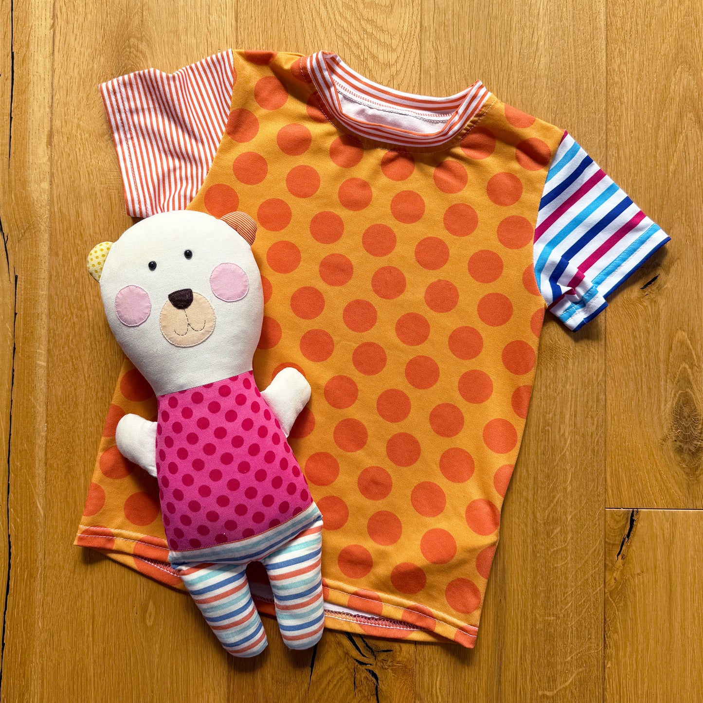 DĚTSKÉ ORANŽOVÉ TRIČKO S KULATÝM VÝSTŘIHEM A RŮŽOVÝM MEDVÍDKEM